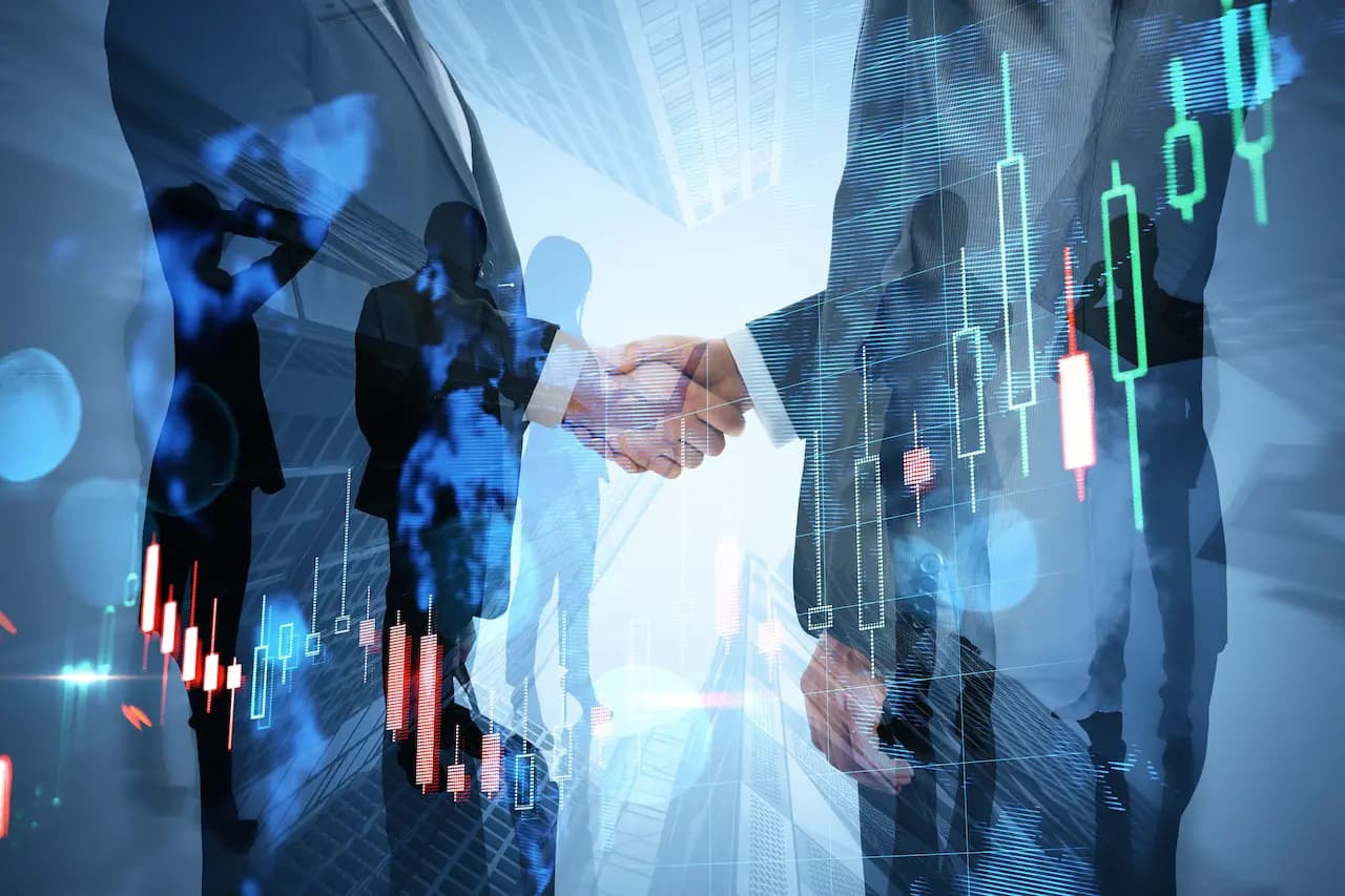 Business handshake overlaid with digital market charts