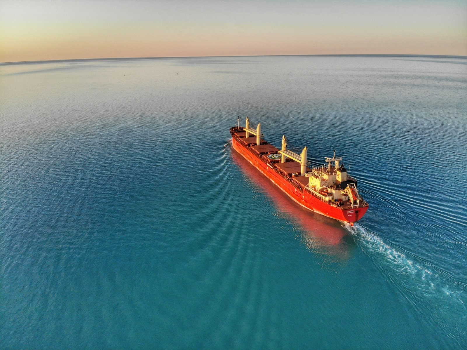 Bulk carrier at sea representing the ocean freight lanes connecting the Houston, Rotterdam, and Singapore hubs